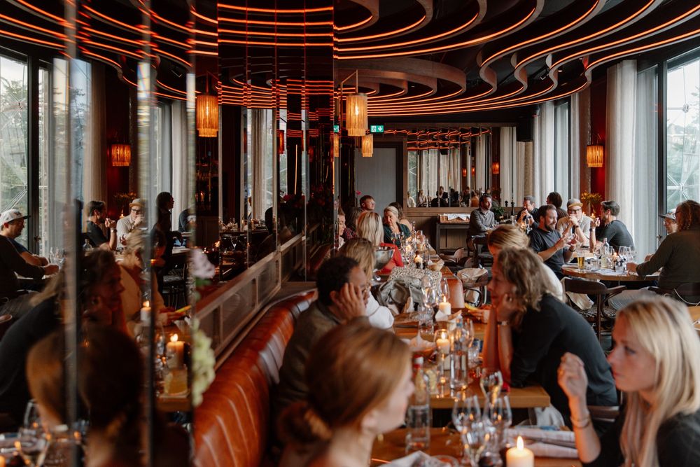 A busy evening in the Bistro: groups dining by candlelight along the leather banquette